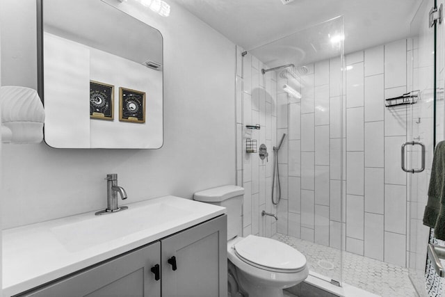 bathroom with a shower with shower door, toilet, and vanity