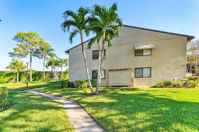 view of home's exterior with cooling unit and a lawn