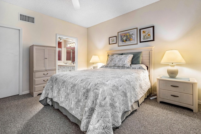 bedroom featuring a textured ceiling, ceiling fan, carpet flooring, and connected bathroom