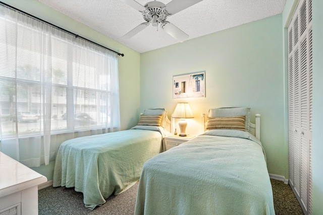 carpeted bedroom featuring a textured ceiling, a closet, and ceiling fan