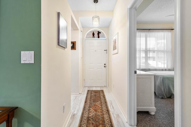 doorway to outside featuring a textured ceiling