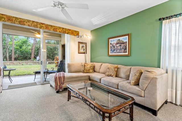 carpeted living room featuring a textured ceiling and ceiling fan