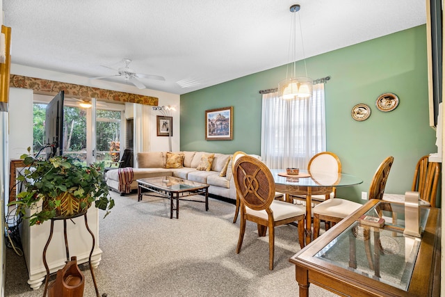 carpeted dining room featuring ceiling fan and a textured ceiling