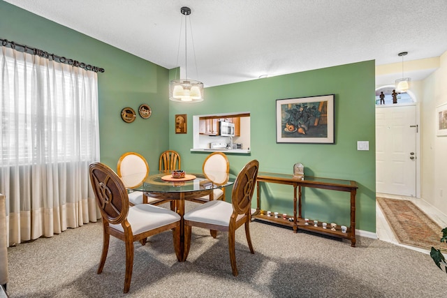 dining space with carpet floors and a textured ceiling