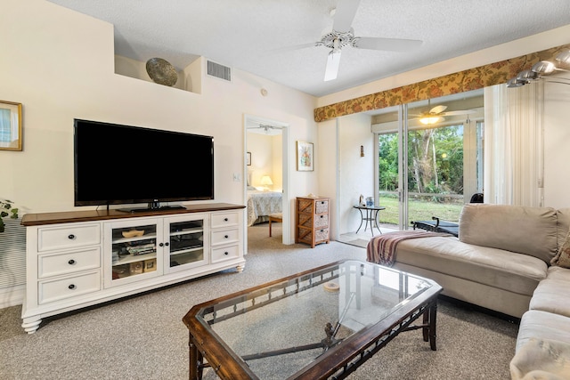 carpeted living room with ceiling fan and a textured ceiling