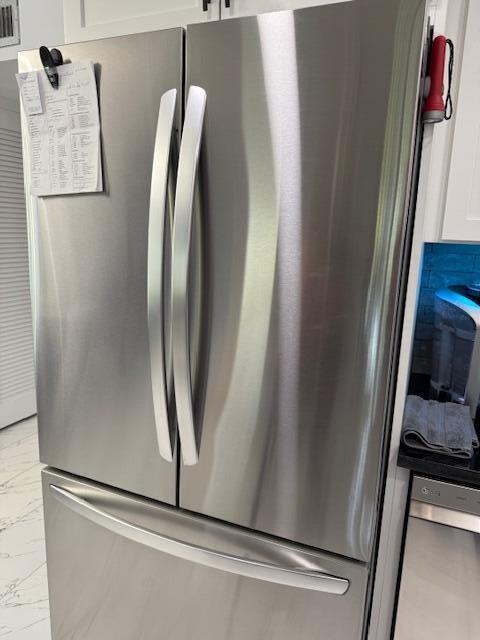 details with white cabinets and stainless steel fridge