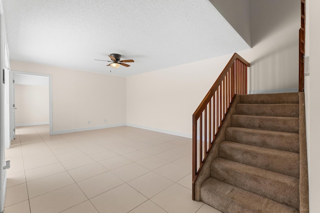 staircase with tile patterned flooring and ceiling fan