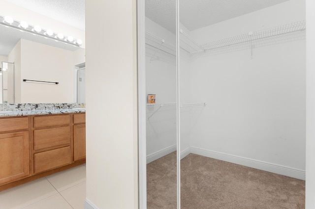 walk in closet featuring light colored carpet