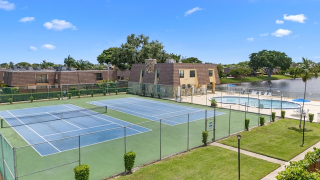 view of sport court featuring basketball court, a yard, a water view, and a community pool