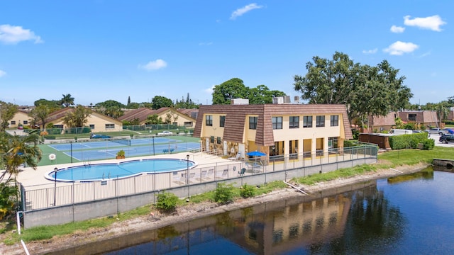 view of pool with a water view and tennis court