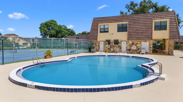 view of pool with tennis court