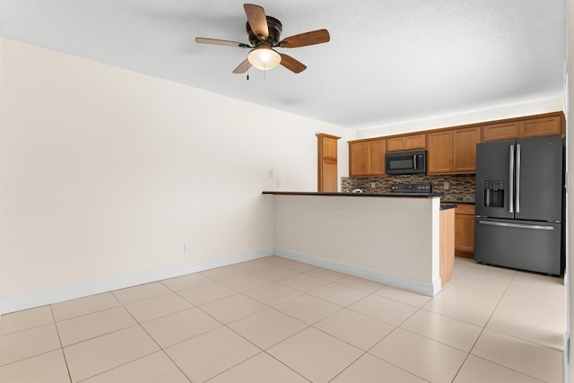 kitchen featuring kitchen peninsula, tasteful backsplash, ceiling fan, black appliances, and light tile patterned floors