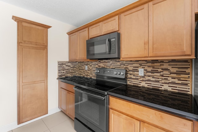 kitchen featuring light brown cabinets, black appliances, dark stone countertops, tasteful backsplash, and light tile patterned flooring