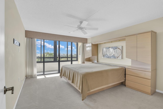 carpeted bedroom with a textured ceiling, ceiling fan, and access to exterior