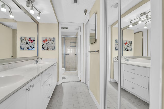 bathroom featuring a textured ceiling, tile patterned floors, vanity, toilet, and walk in shower