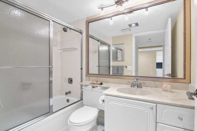 full bathroom with toilet, vanity, and bath / shower combo with glass door