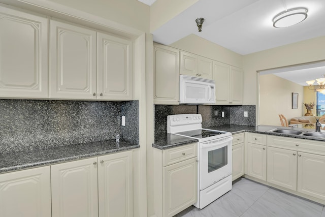 kitchen featuring an inviting chandelier, backsplash, white appliances, dark stone countertops, and sink