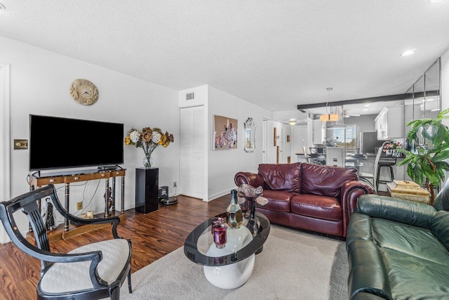 living room with wood-type flooring and a textured ceiling