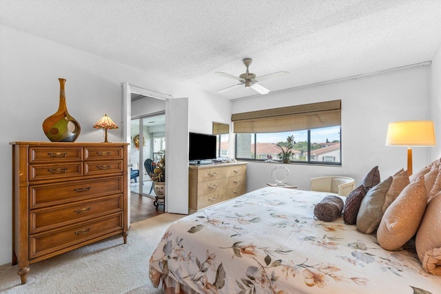 bedroom with light carpet, a textured ceiling, and ceiling fan