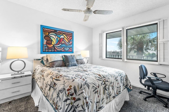 bedroom with a textured ceiling, dark carpet, and ceiling fan