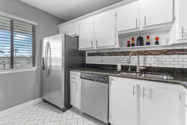 kitchen featuring dark stone countertops, white cabinetry, sink, and appliances with stainless steel finishes