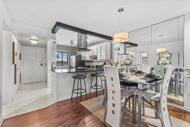 dining space with ceiling fan, hardwood / wood-style floors, a textured ceiling, and sink