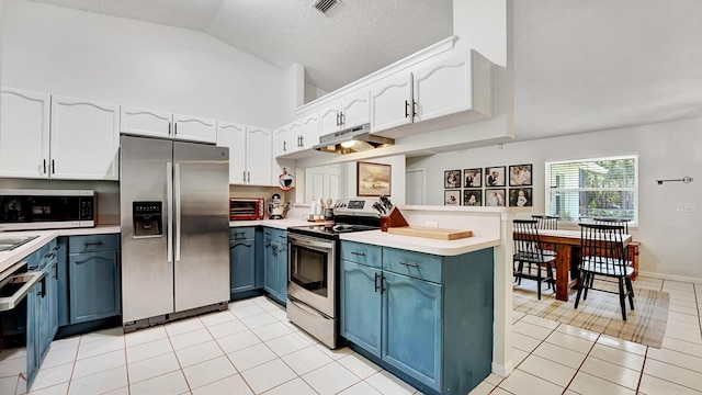 kitchen featuring white cabinetry, appliances with stainless steel finishes, kitchen peninsula, and vaulted ceiling