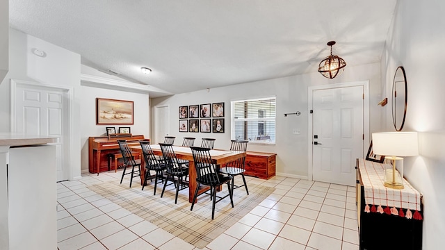 dining area featuring lofted ceiling, a notable chandelier, and light tile patterned flooring