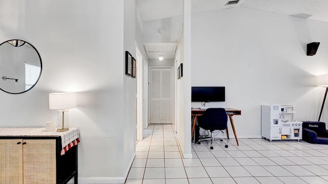 office space with light tile patterned floors and lofted ceiling