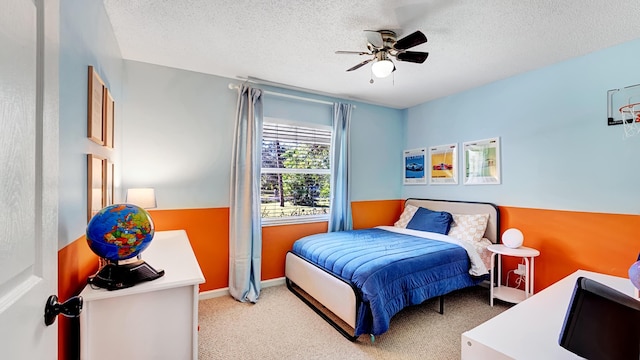 carpeted bedroom featuring ceiling fan and a textured ceiling