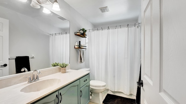 bathroom featuring tile patterned floors, toilet, vanity, and walk in shower