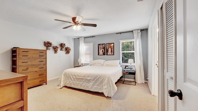 bedroom featuring ceiling fan, carpet, and a textured ceiling