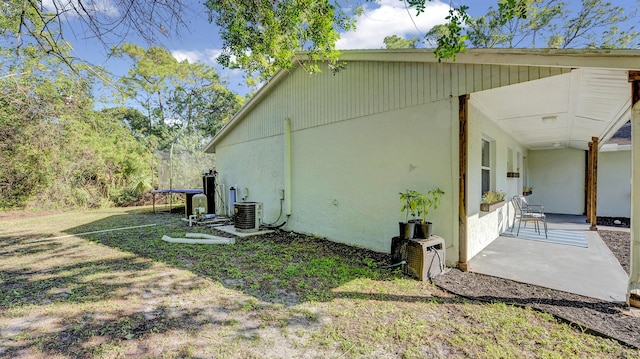 view of property exterior featuring a patio area, central air condition unit, and a yard