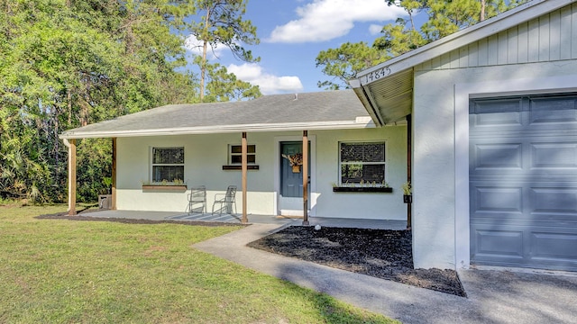 view of front of house featuring a garage, a front yard, and a porch