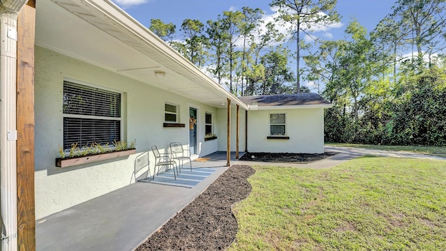 entrance to property with a patio area and a yard