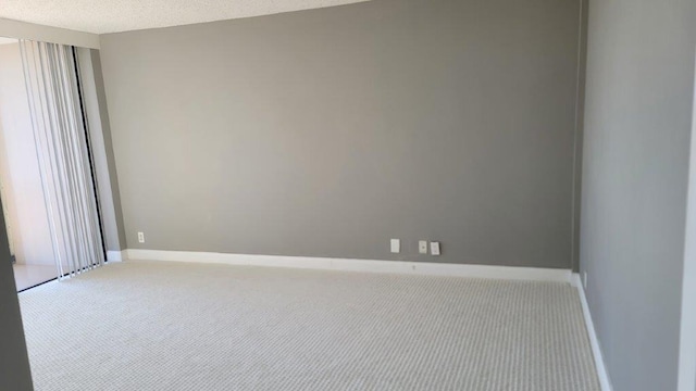 carpeted empty room with a textured ceiling