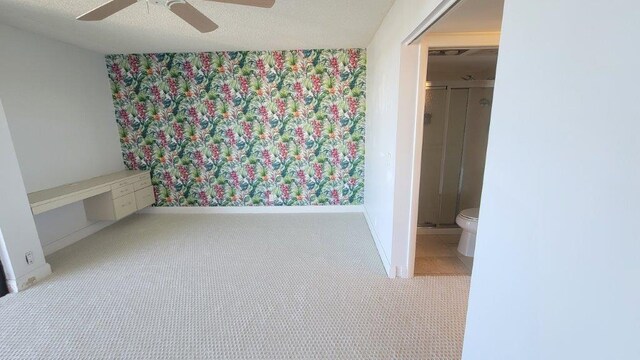 unfurnished bedroom with ceiling fan and ensuite bath