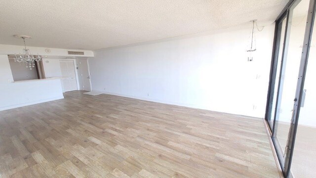 interior space featuring wood-type flooring, a textured ceiling, and a notable chandelier