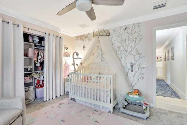 bedroom with carpet, visible vents, ornamental molding, a nursery area, and wallpapered walls