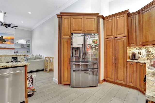 kitchen with crown molding, appliances with stainless steel finishes, brown cabinets, and light stone counters