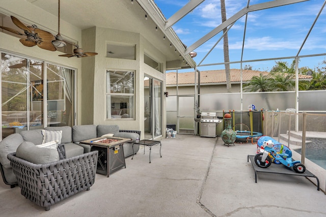 view of patio / terrace with a lanai, an outdoor living space with a fire pit, ceiling fan, and area for grilling