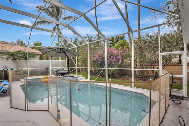 view of pool with glass enclosure and a patio area