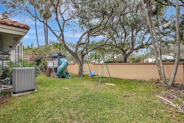 view of yard featuring cooling unit, a playground, and fence