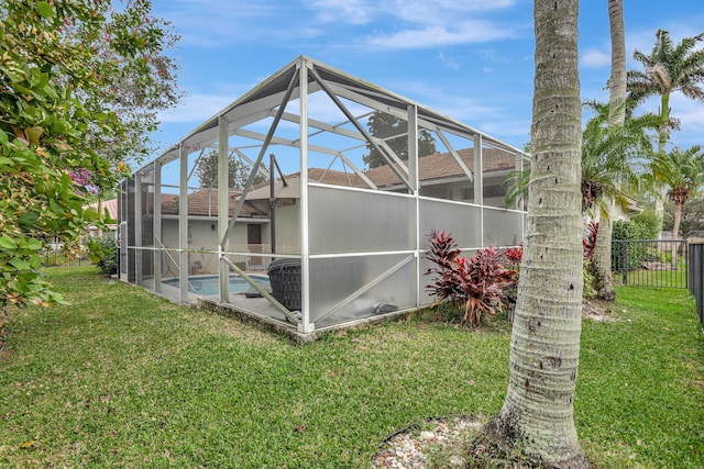 back of property with a yard, fence, a fenced in pool, and a lanai