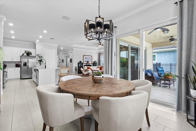 tiled dining room featuring ceiling fan with notable chandelier, ornamental molding, and sink