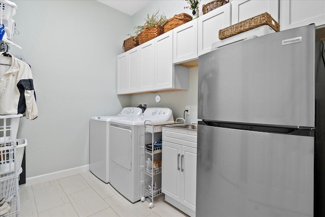 clothes washing area featuring cabinets and separate washer and dryer