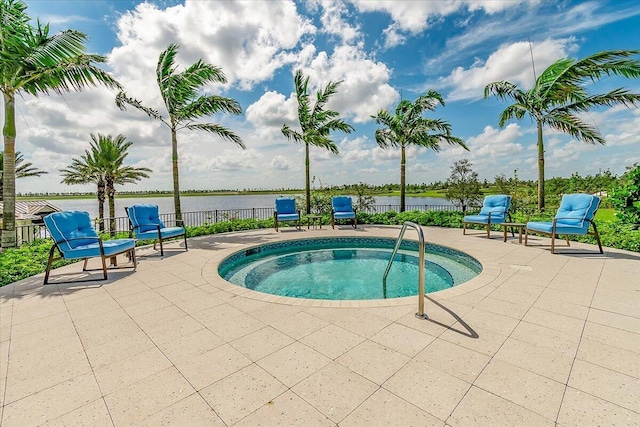 view of swimming pool featuring a patio area, an in ground hot tub, and a water view