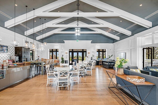 dining space featuring light hardwood / wood-style floors, french doors, high vaulted ceiling, and beamed ceiling