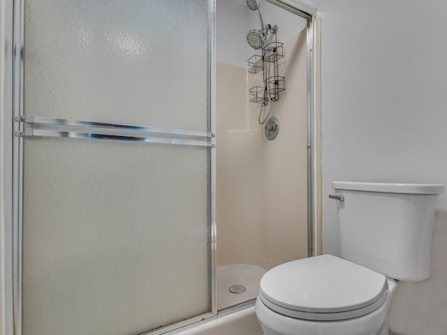 bathroom with toilet and an enclosed shower