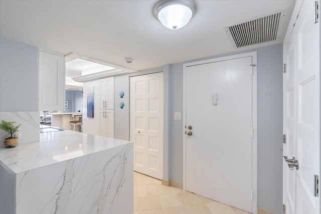 kitchen with white cabinets and light stone countertops